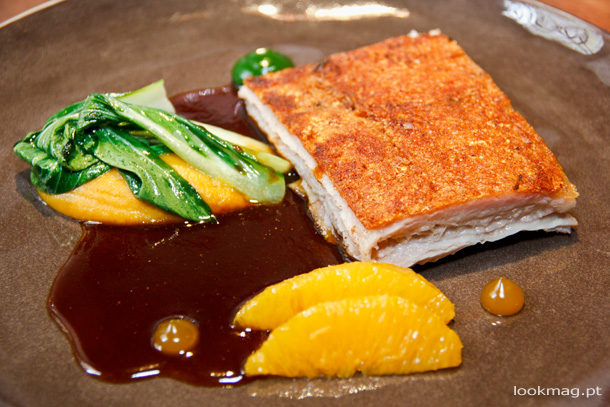 Leitão confitado, puré de batata doce, pak choi e jus de laranja
